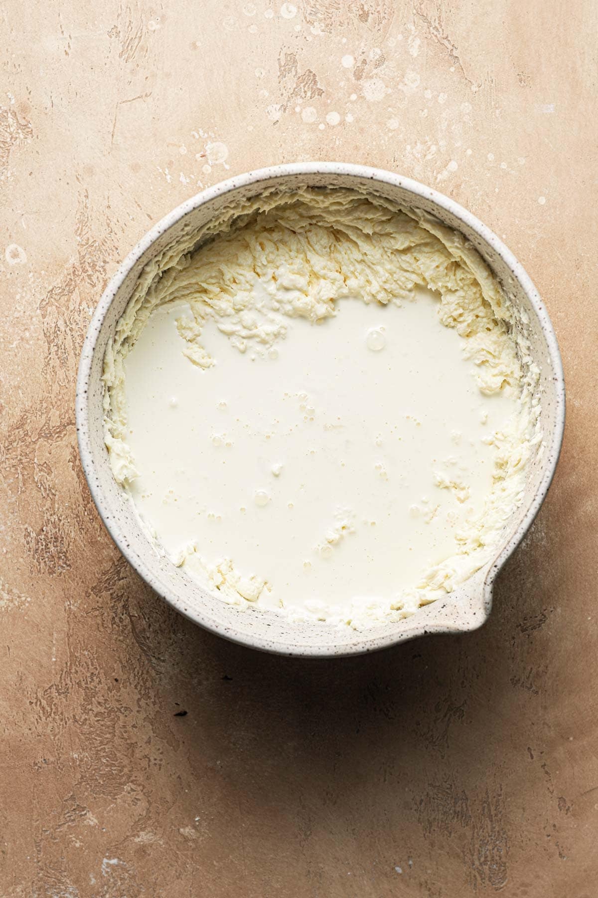 A large bowl with whipped mascarpone cream and cream poured over it.