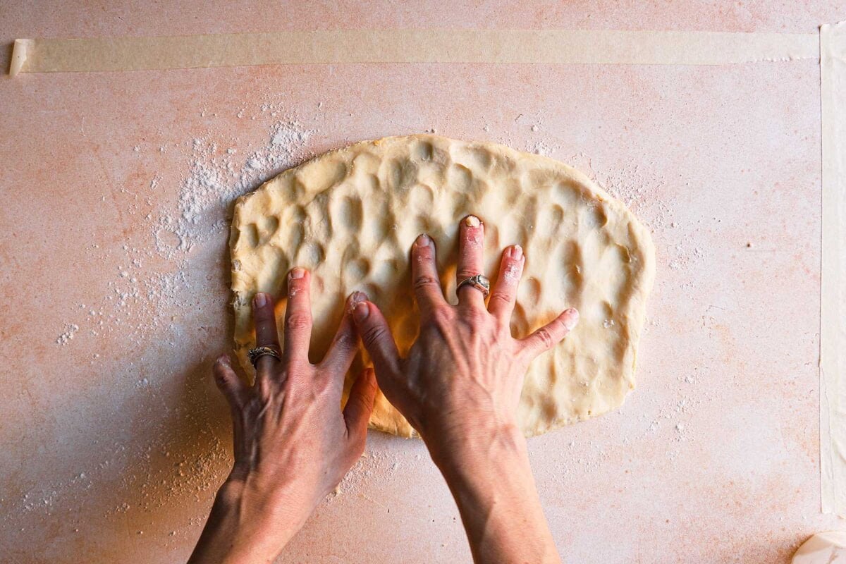 hands pressing doen dough.