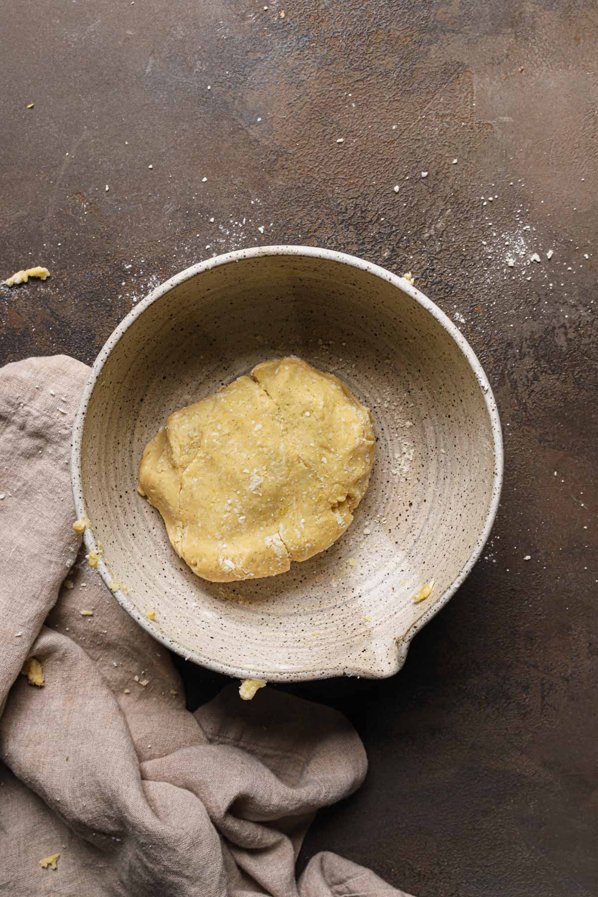 A large bowl with a piece of dough.