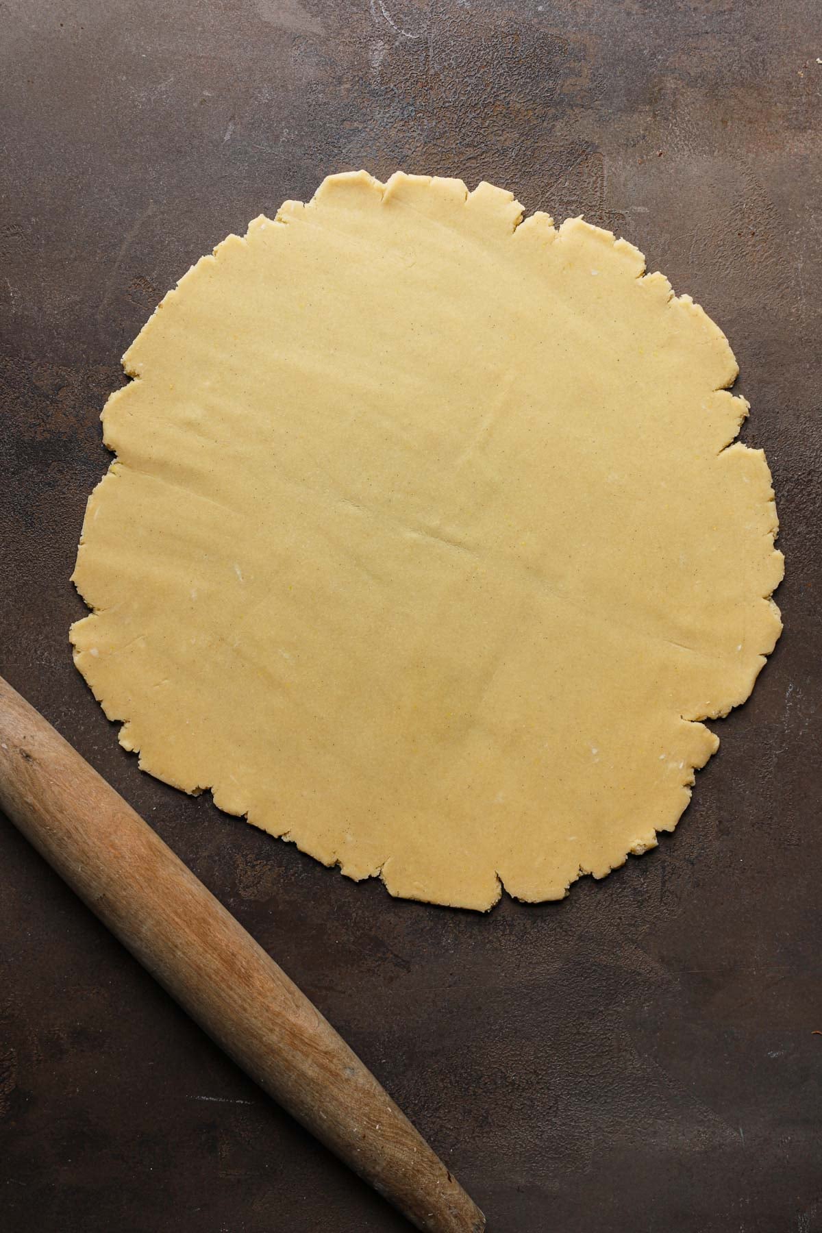 Rolled dough next to a rolling pin.