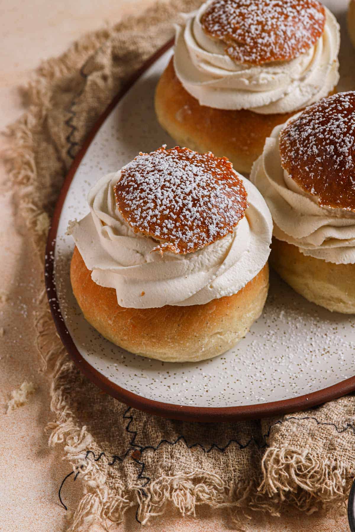 Semla topped with cream and powdered sugar.