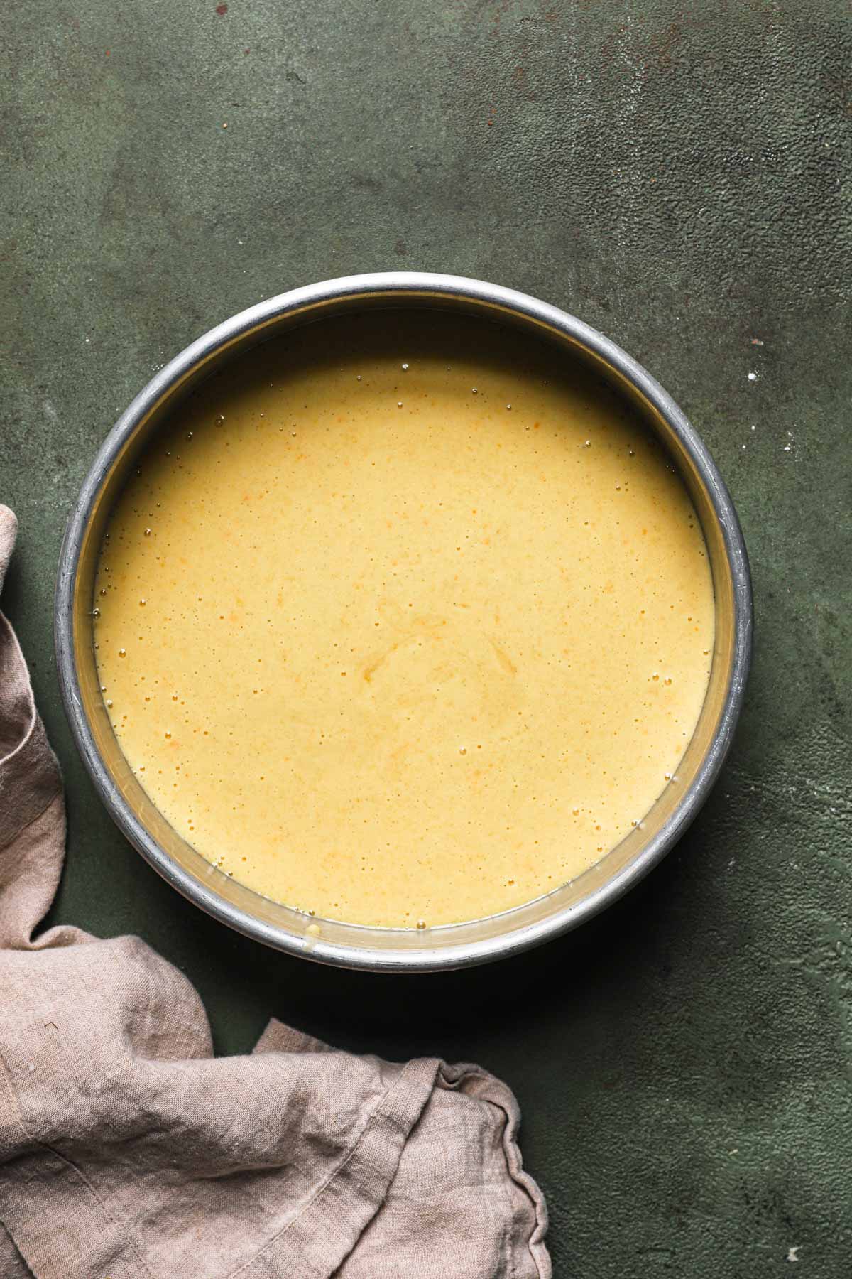 A pan filled with unbaked whole orange cake batter.