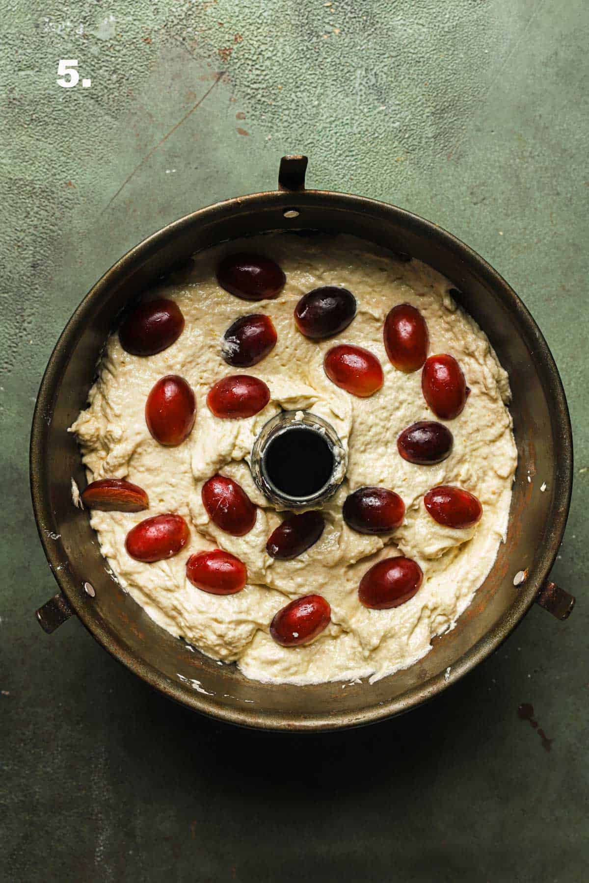 a pan filled with raw cake batter and grapes