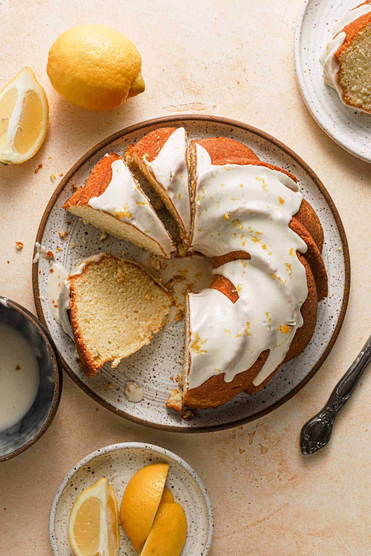 A bundt cake with glaze and lemons around it.
