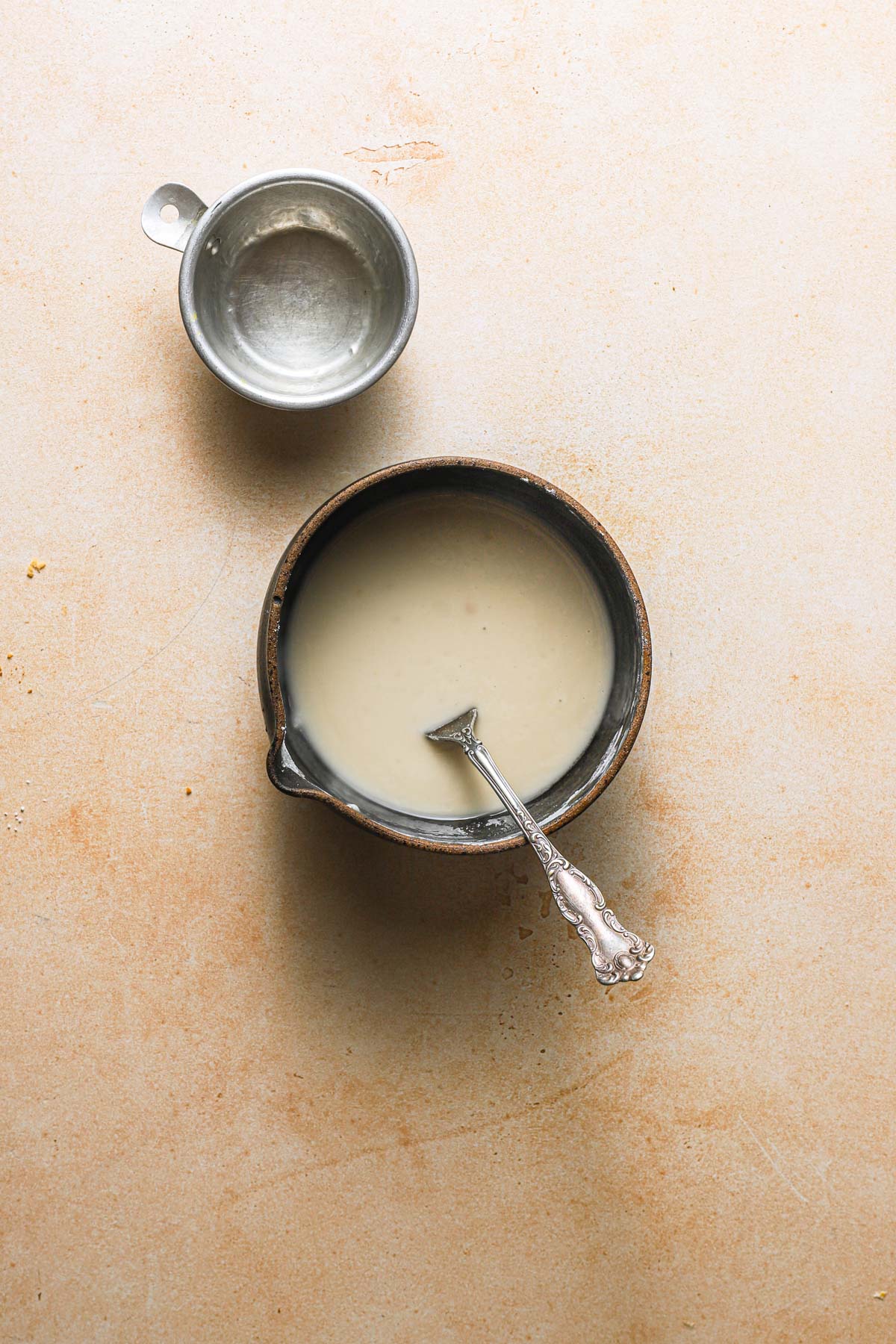 A bowl with lemon glaze and an empty cup.