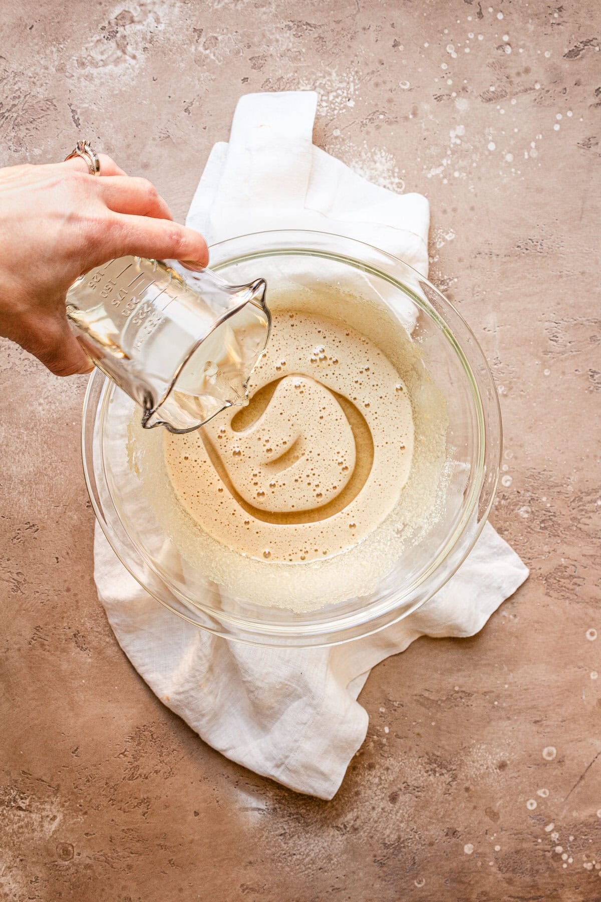 Adding oil to a bowl with sugar and eggs.