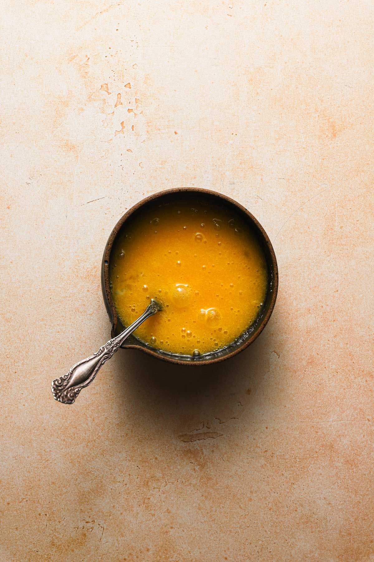 A bowl with a fork and egg-sugar mixture.