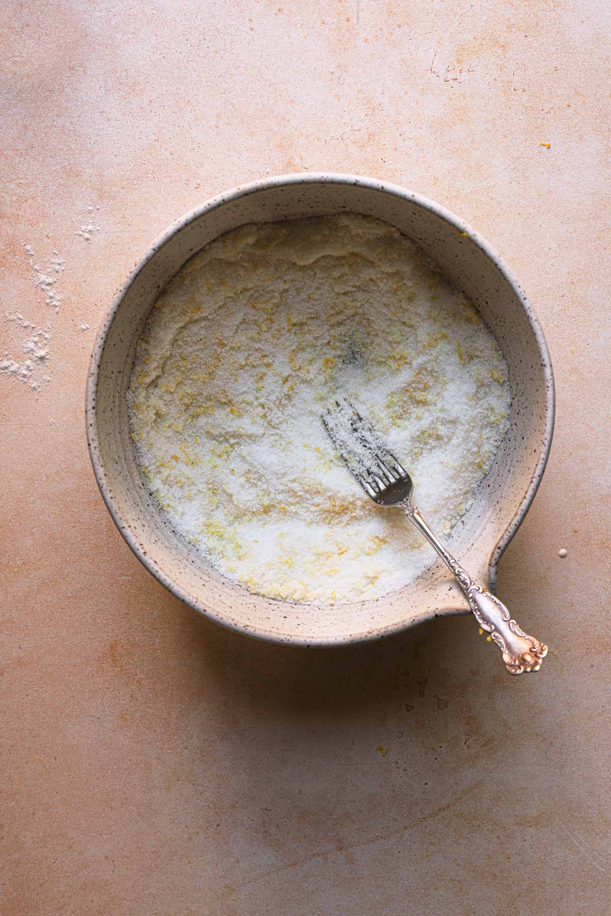 A bowl with sugar and lemon zest.