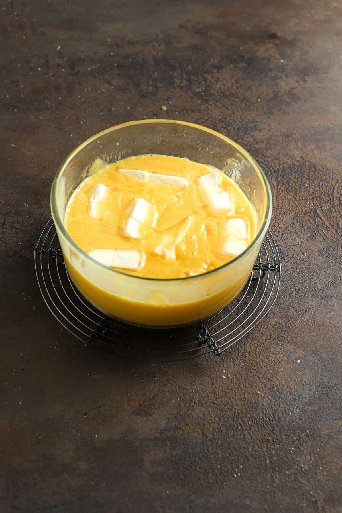 Chunks of butter in a bowl full of custard.