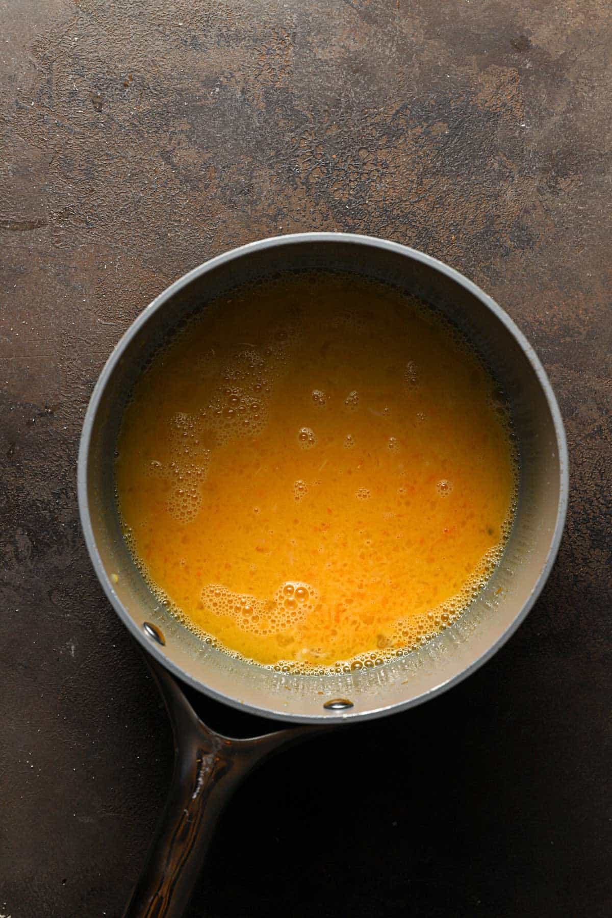 A saucepan with ingredients to make custard.