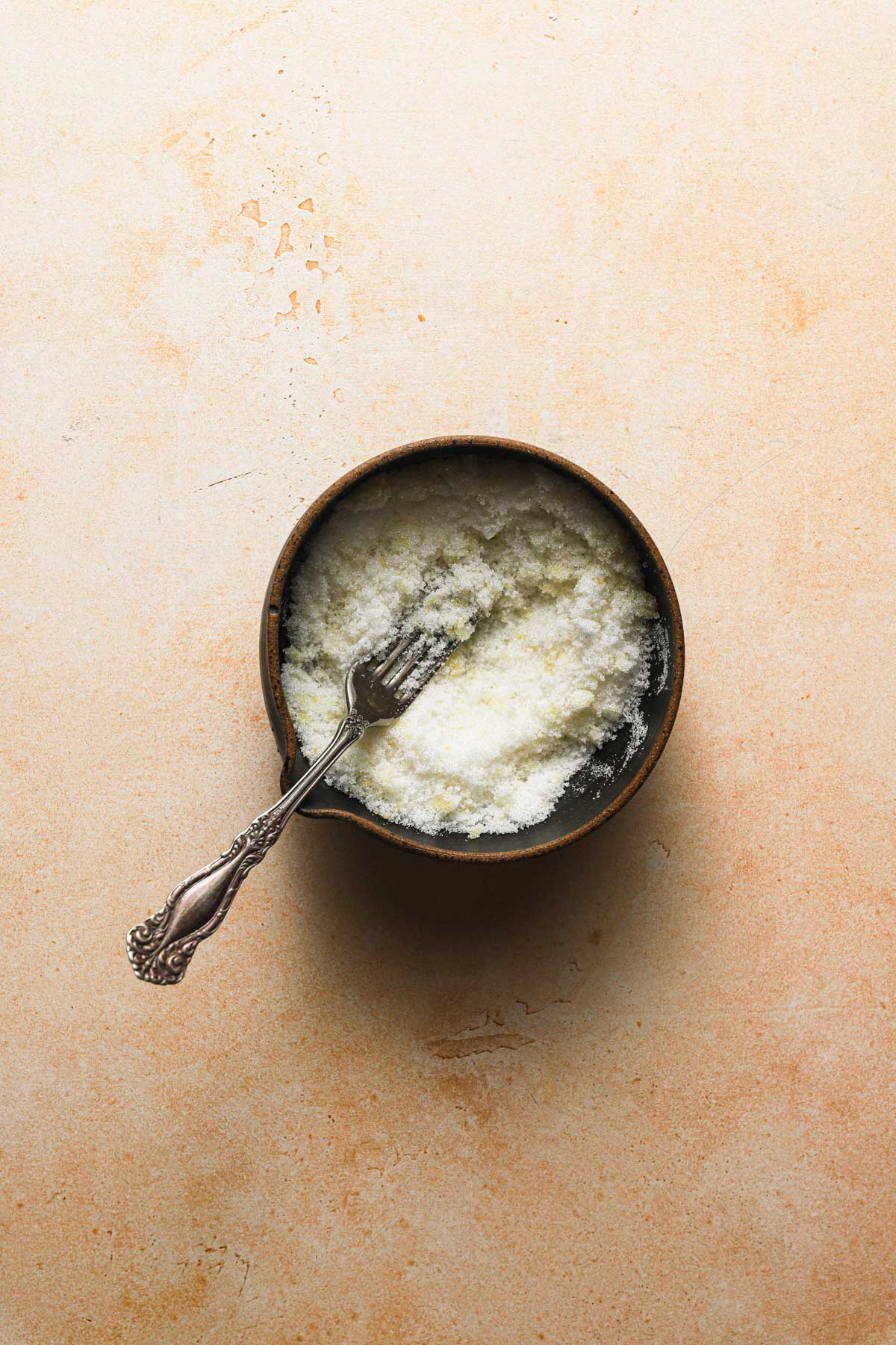 a bowl with sugar and a fork.