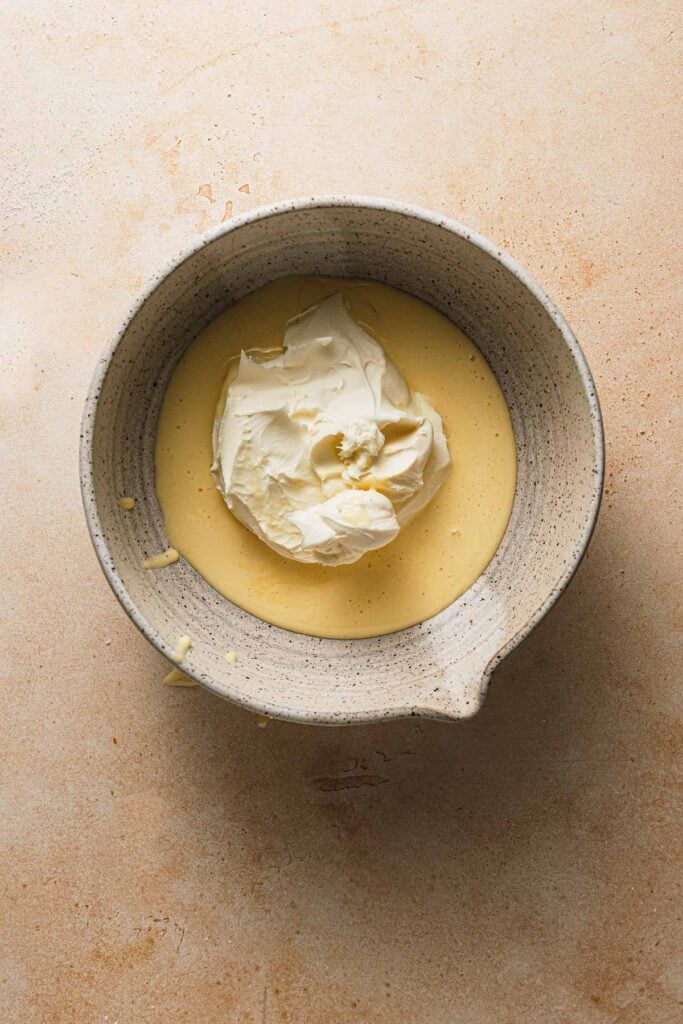 A large bowl with egg yolk mixture and mascarpone cheese.