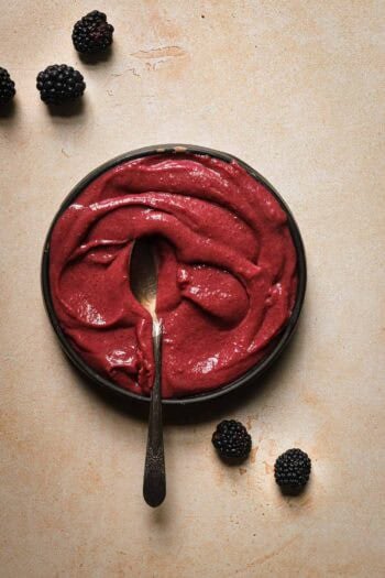 pink custard in a bowl with a spoon.