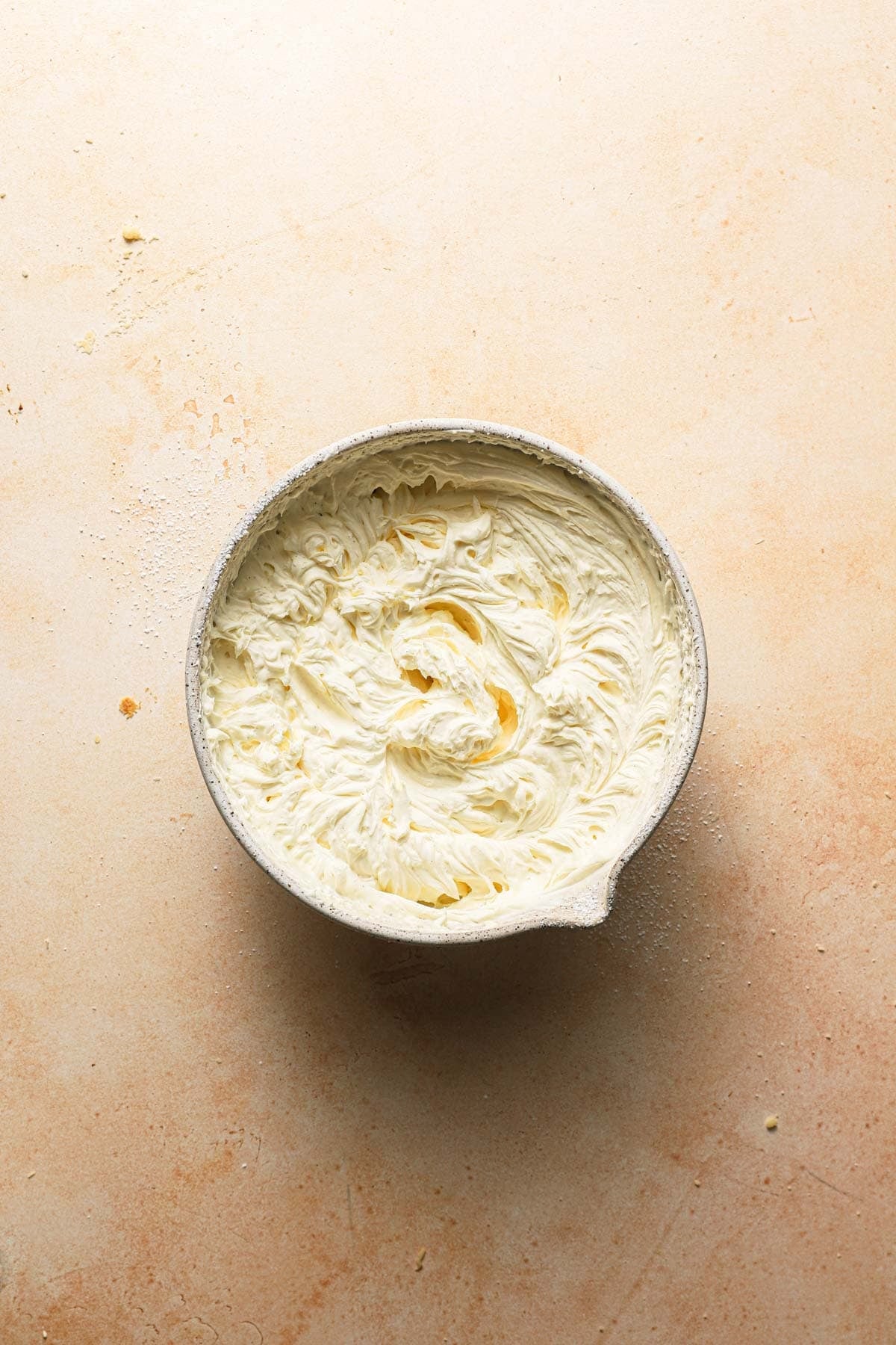 A large bowl with cream cheese cake filling.