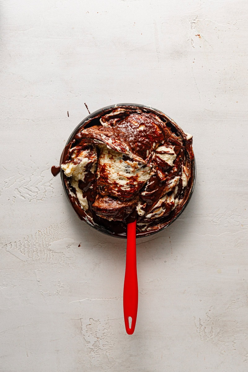 A bowl with dark and light batter and a spatula.