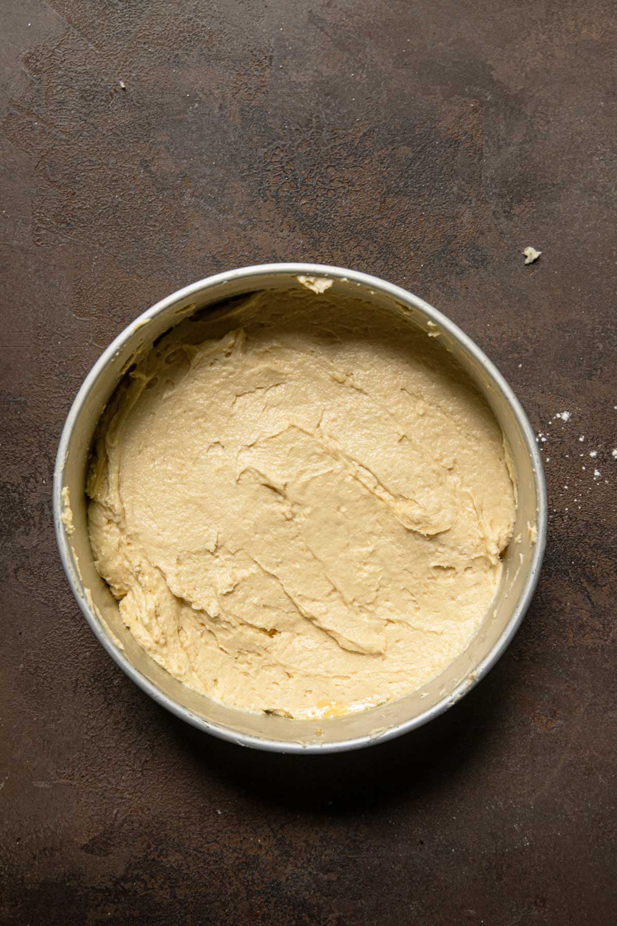A cake pan topped with cake batter.