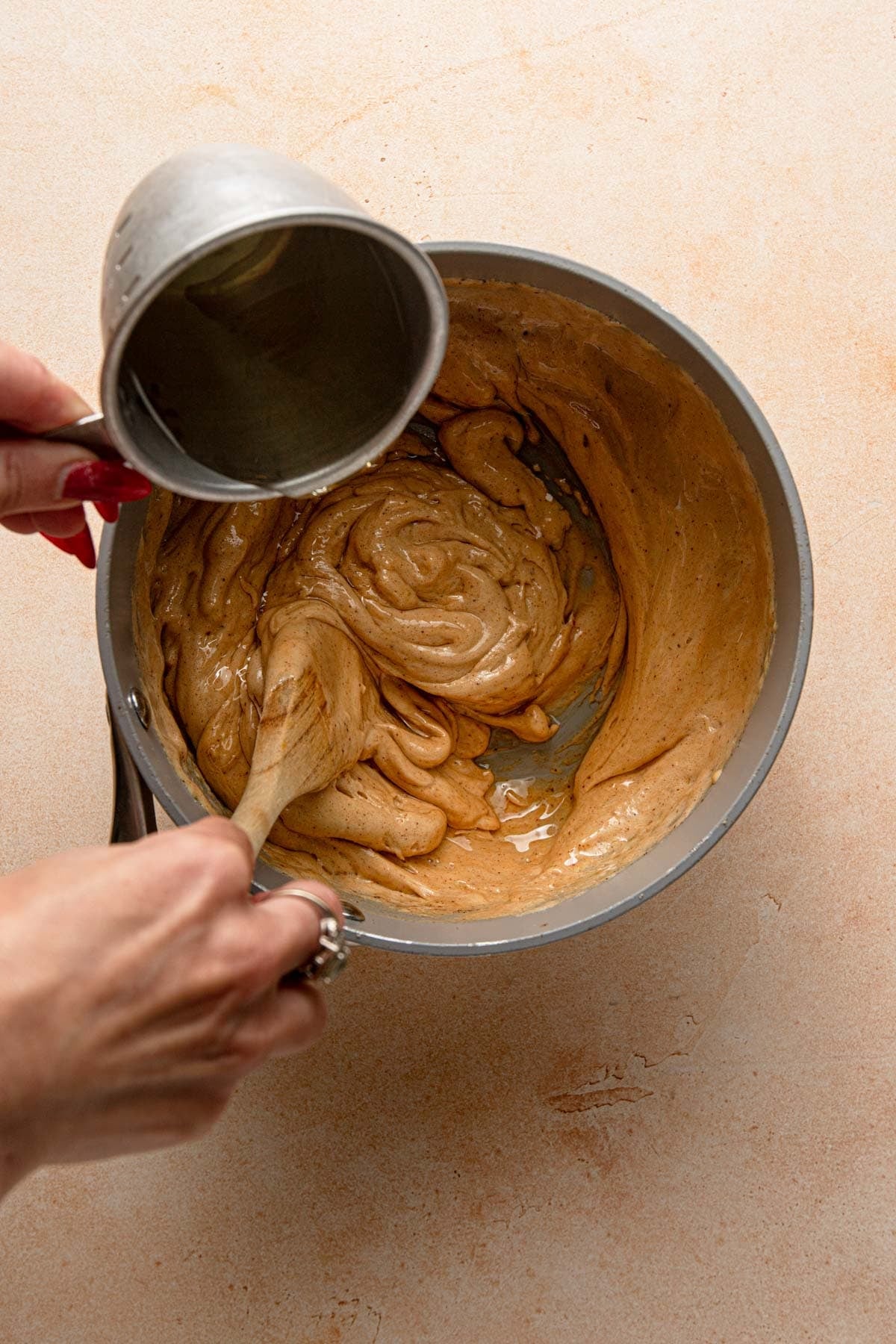 Pouring oil into honey mixture.
