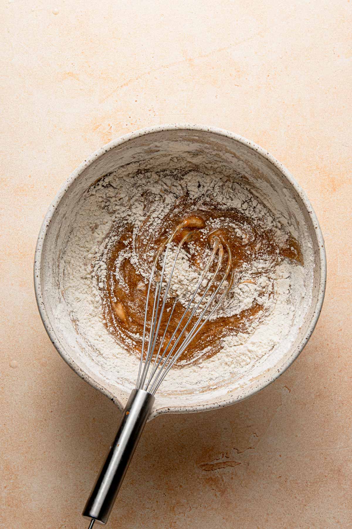 A large bowl with honey mixture and flour.