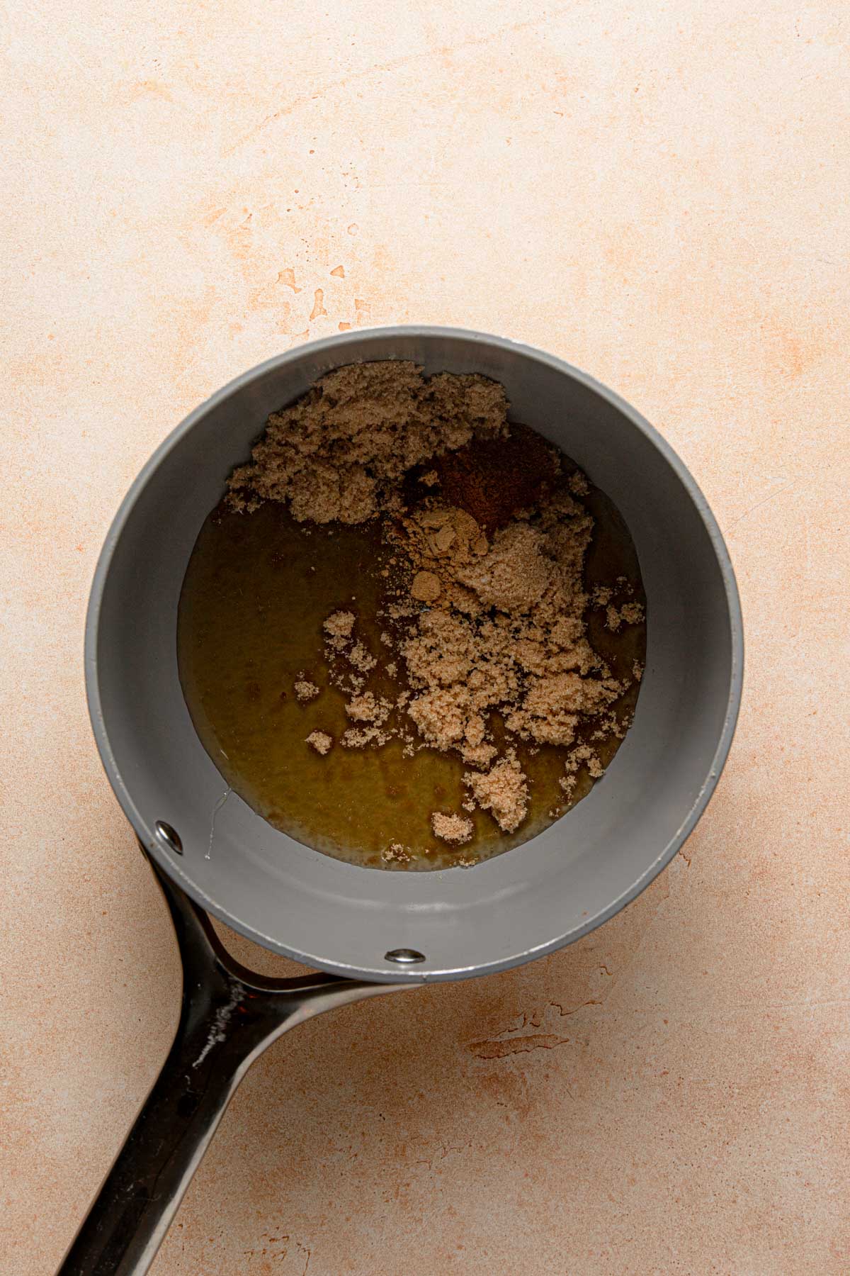 A sauce pan with honey and sugar.
