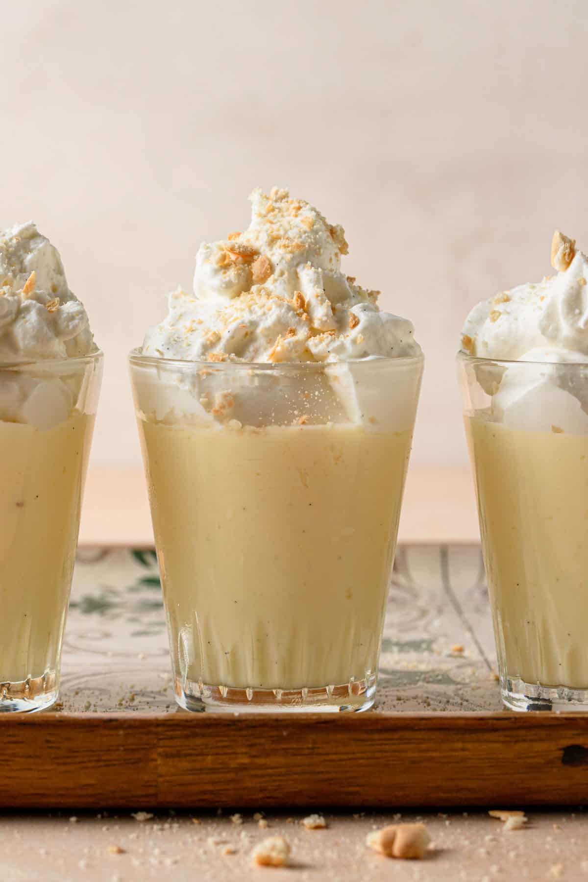 Budino in  glass cups topped with cream and crushed cookies.