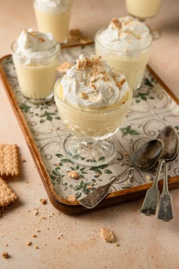 Budino Italian pudding in glass cups with cookies on a serving tray and spoons.
