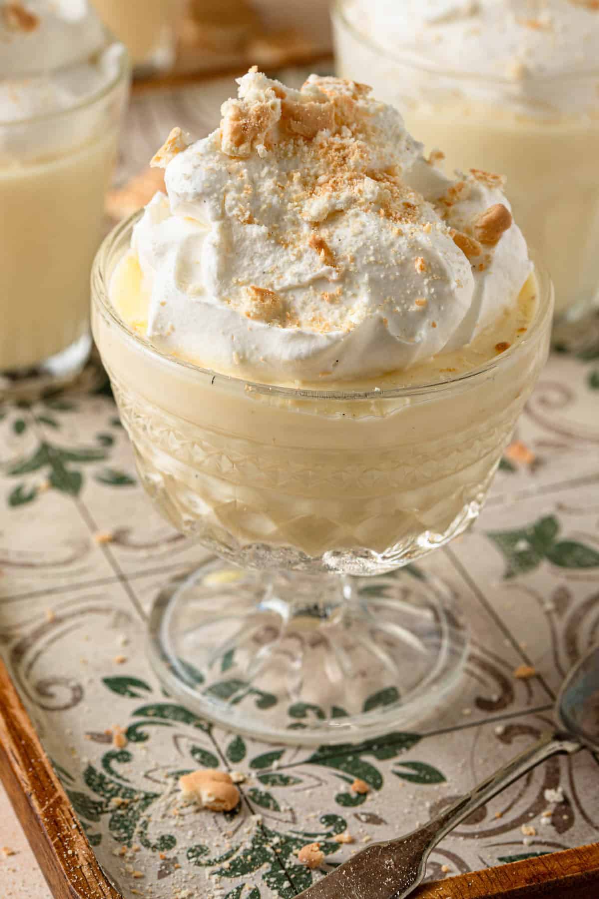 A serving dish filled with pudding and topped with whipped cream and crushed cookies.