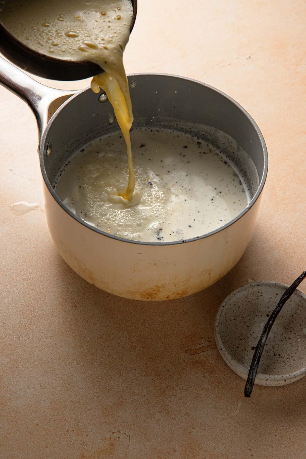 Pouring egg yolk mixture back to the milk mixture.