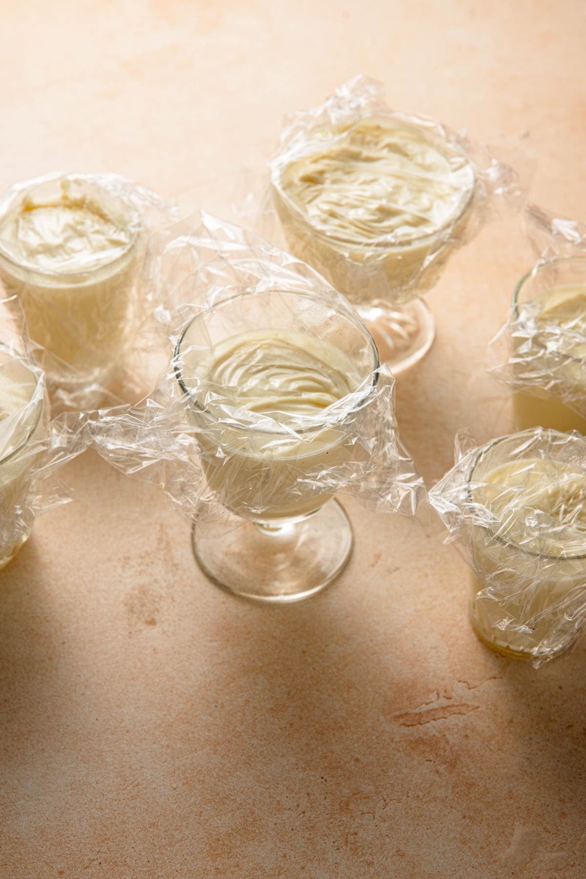 Vanilla Italian Pudding topped with plastic wrap over the surface of the pudding.