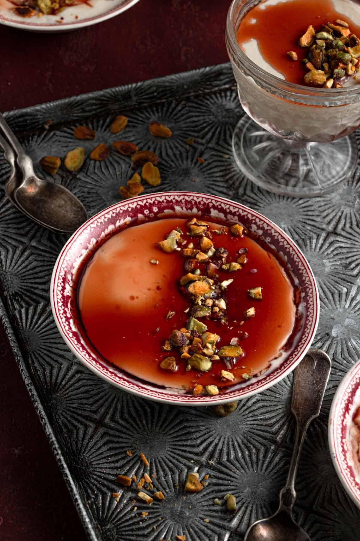 Milk pudding drizzle with syrup and topped with chopped pistachios.