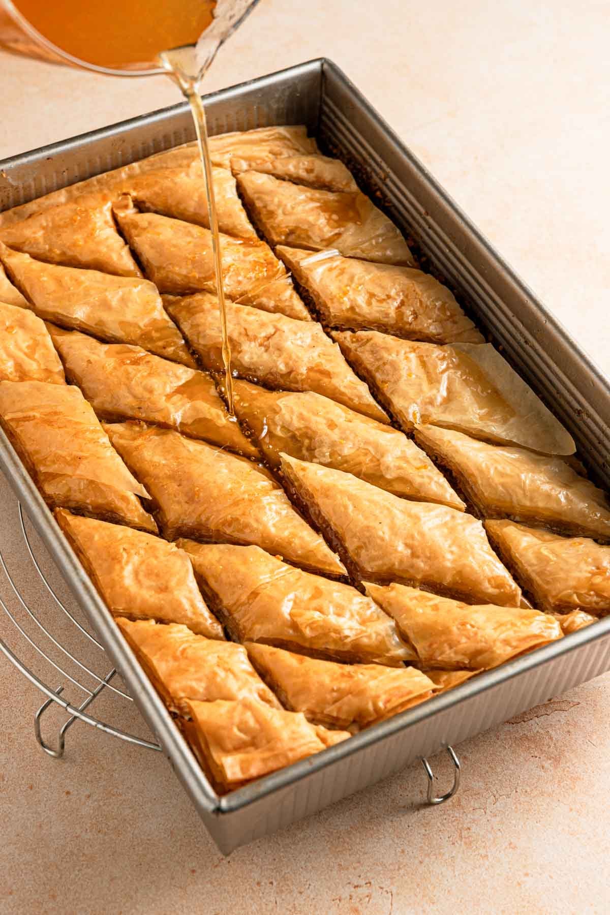 Pouring syrup over baked baklava.