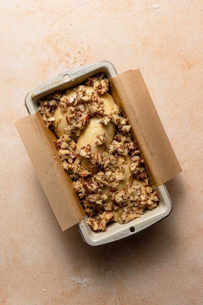 Unbaked babka in a oan with topping.