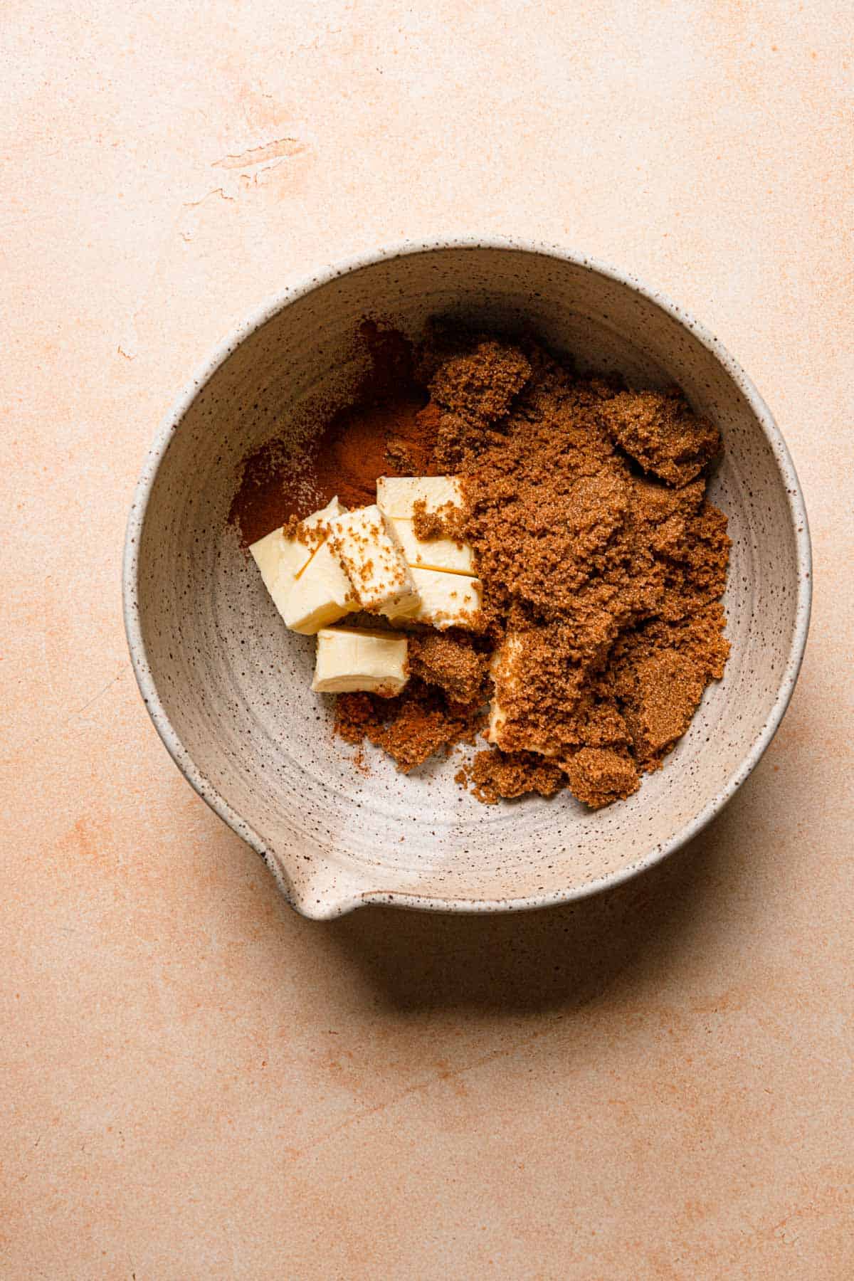 A bowl with butter, brown sugar and ground cinnamon.