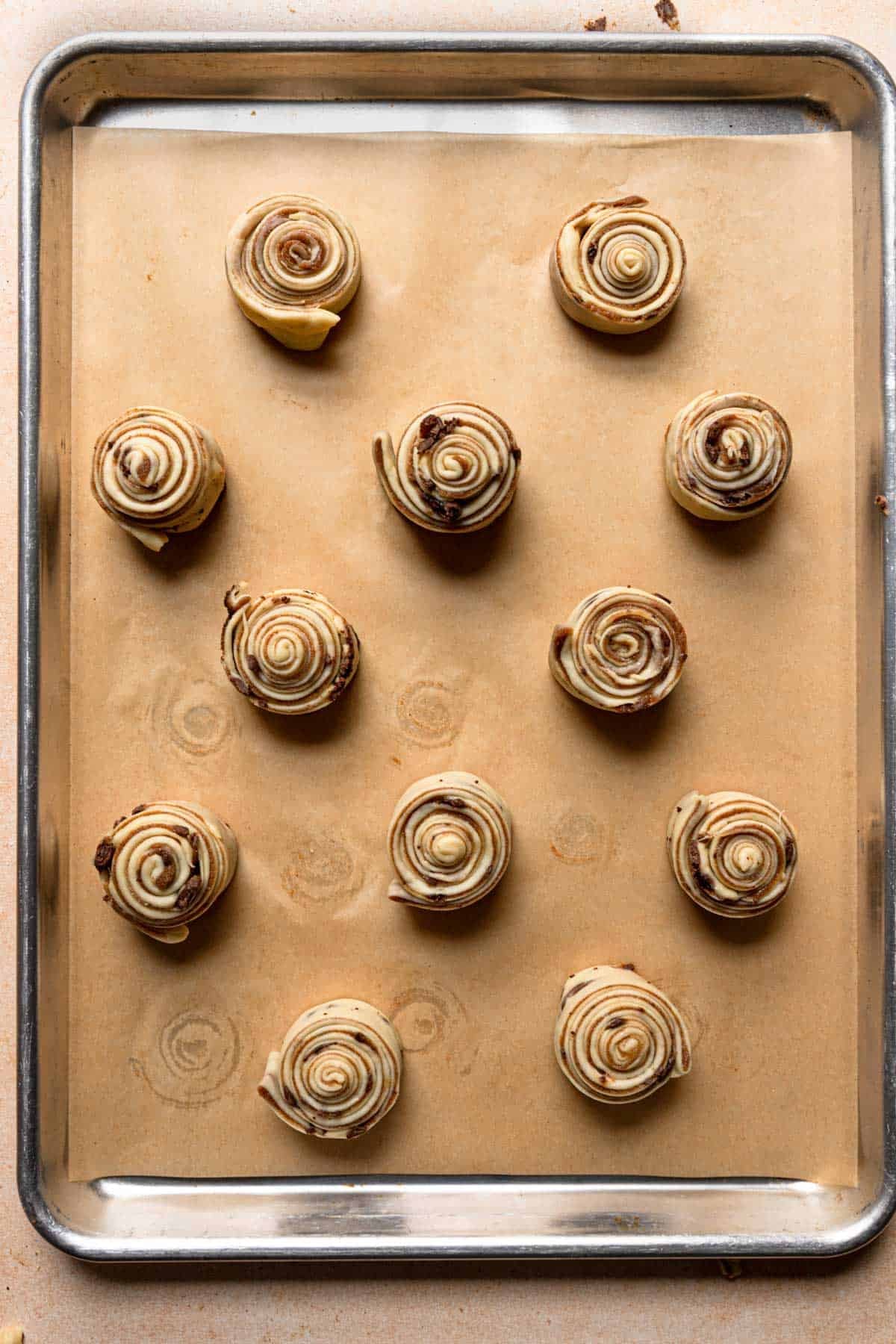 unbaked schnecken on a baking pan with parchment paper.