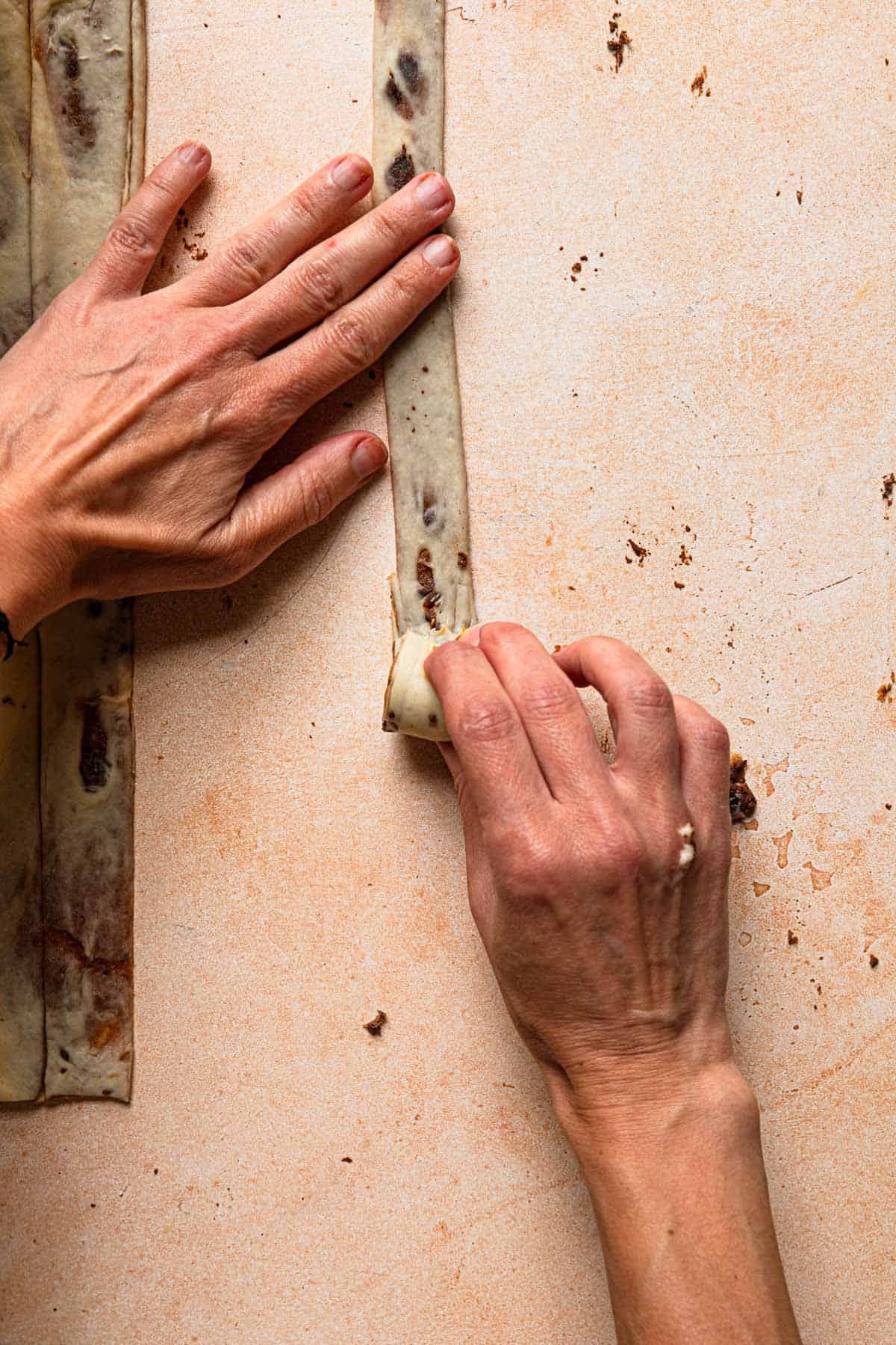 hands rolling cinnamon roll.
