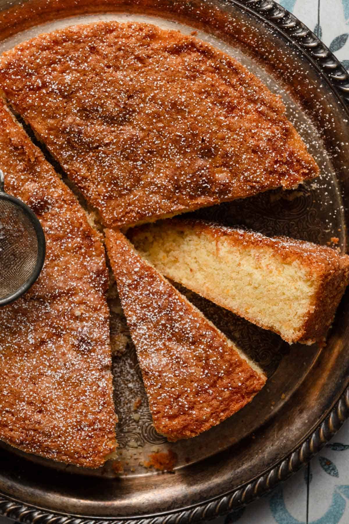 Sliced orange blossom cake dusted with powdered sugar.