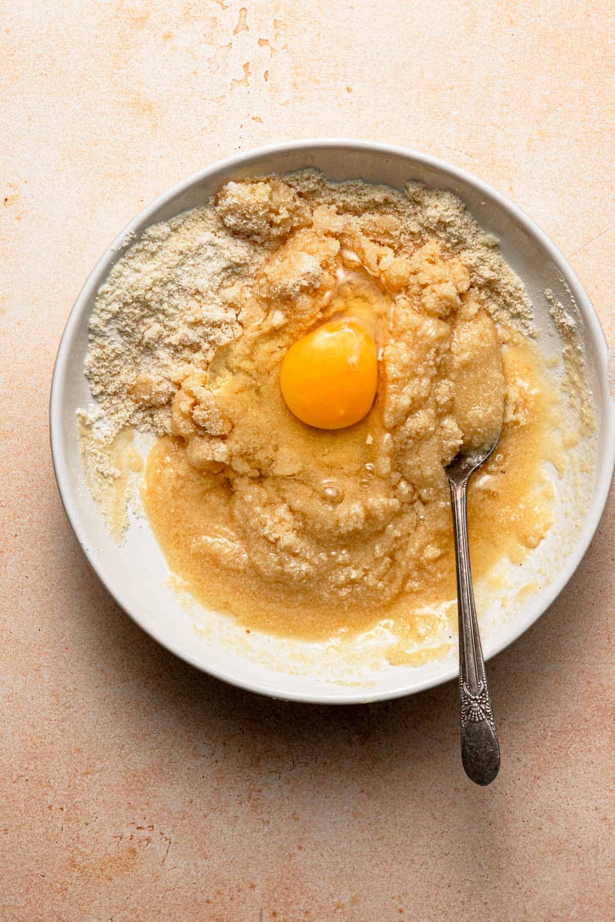 A bowl with almond cream ingredients and a spoon.