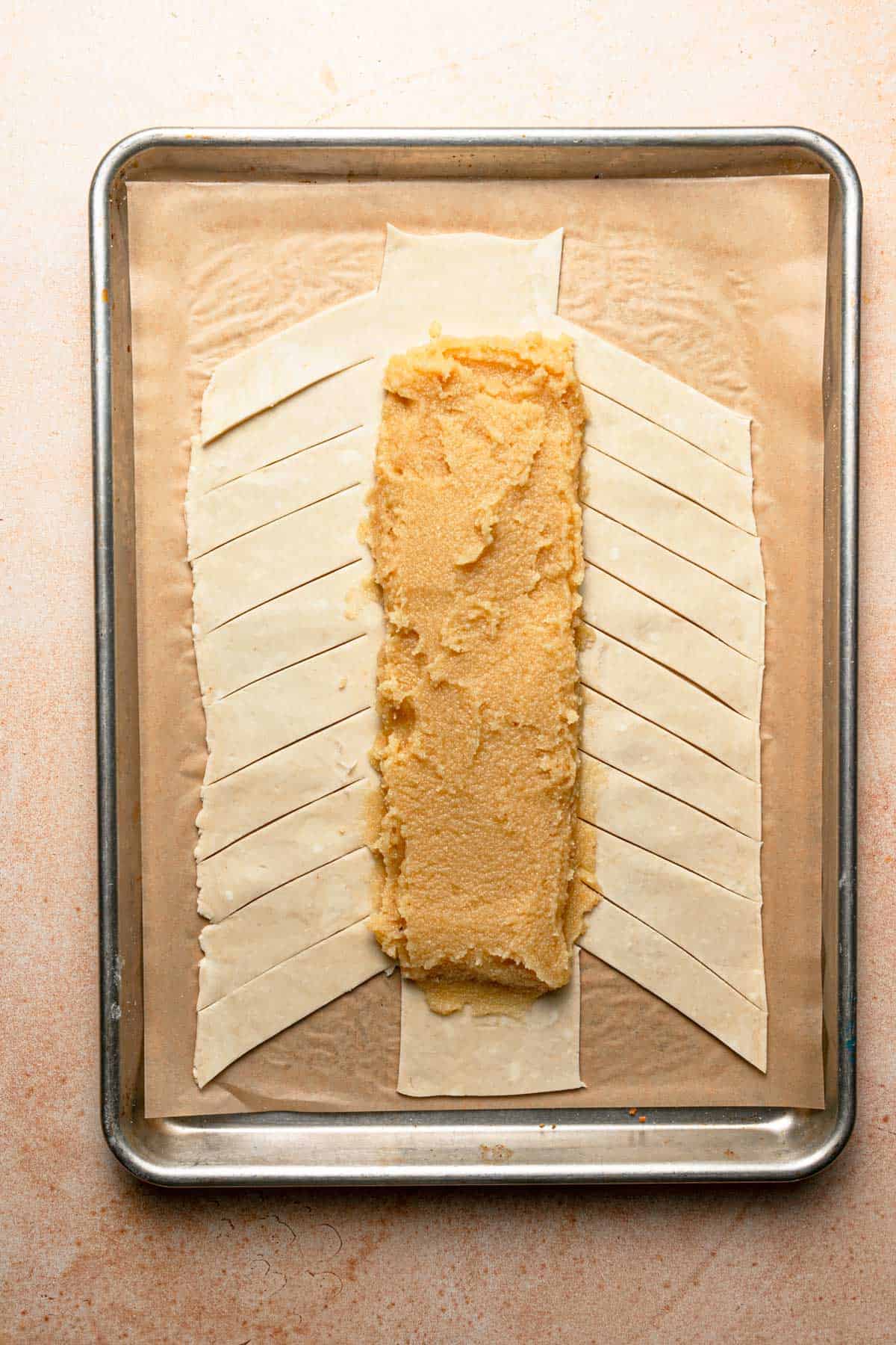 A rectangle dough topped with almond cream and cut into stripes.