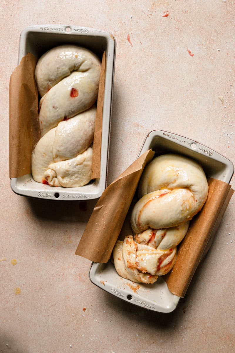 Two loaf pans filled with Raw babka dough.