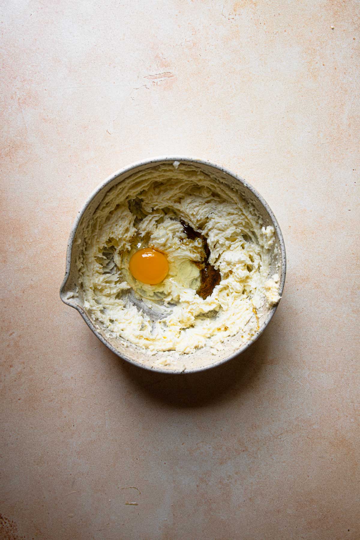a bowl with creamed butter and an egg.