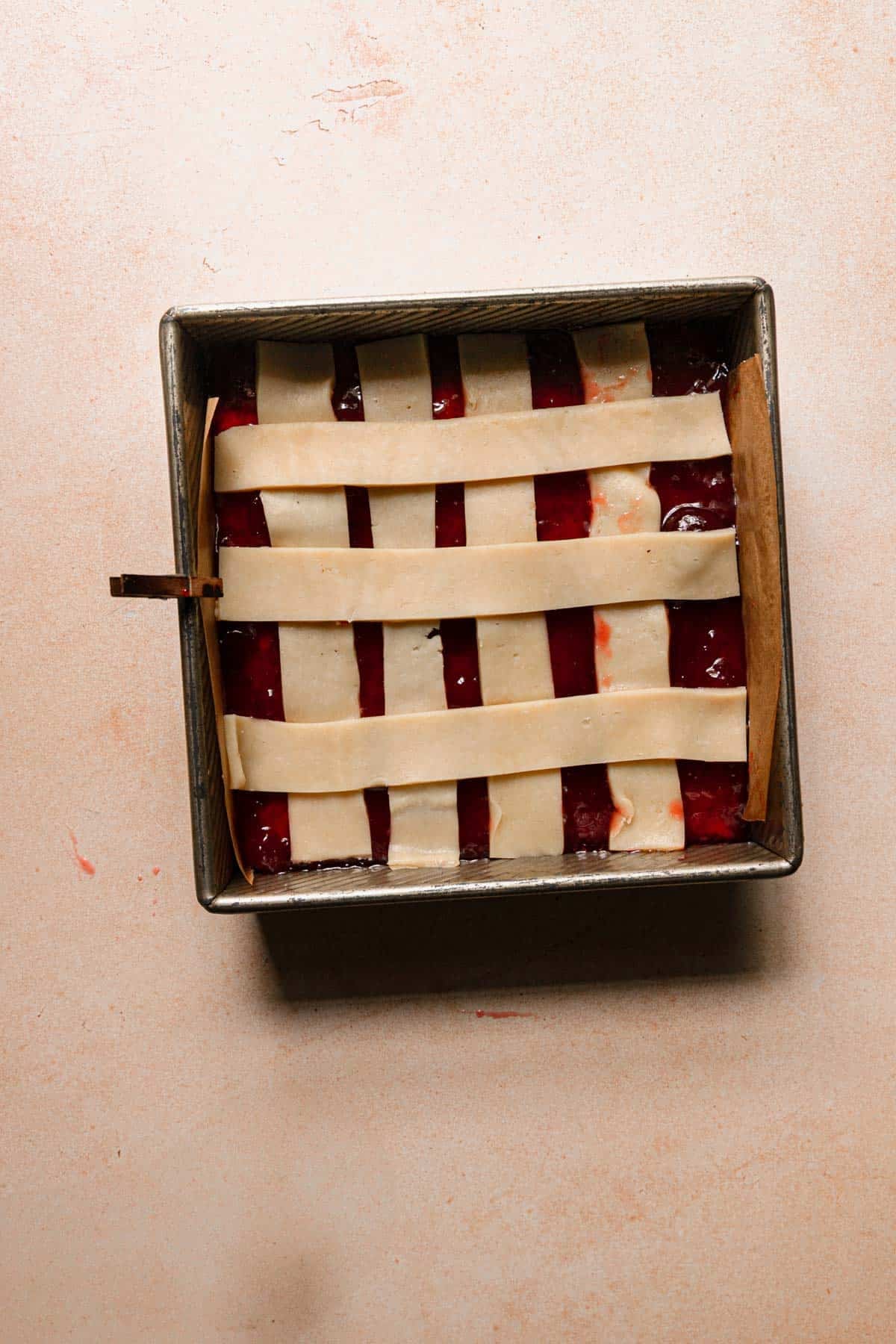Un baked strawberry bars topped with shortbread dough.