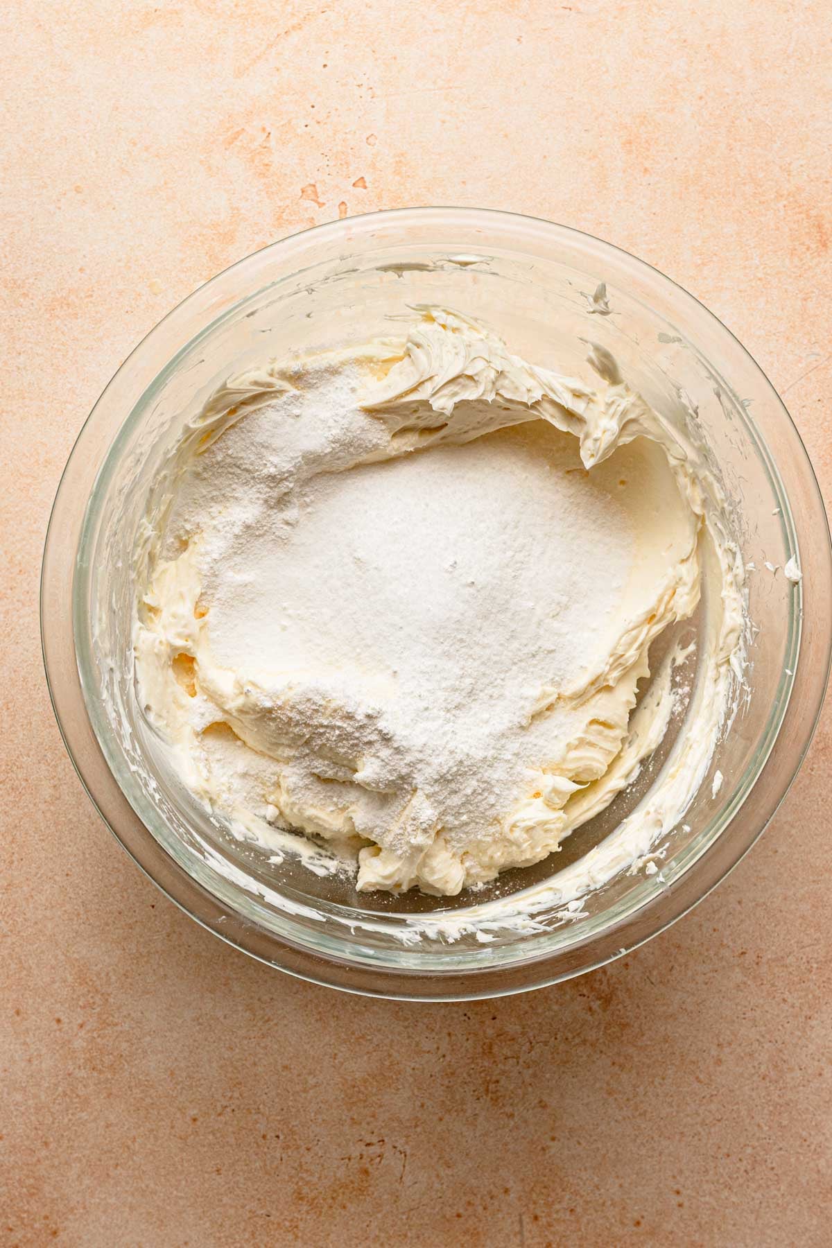 A bowl with whipped cream cheese and sugar.