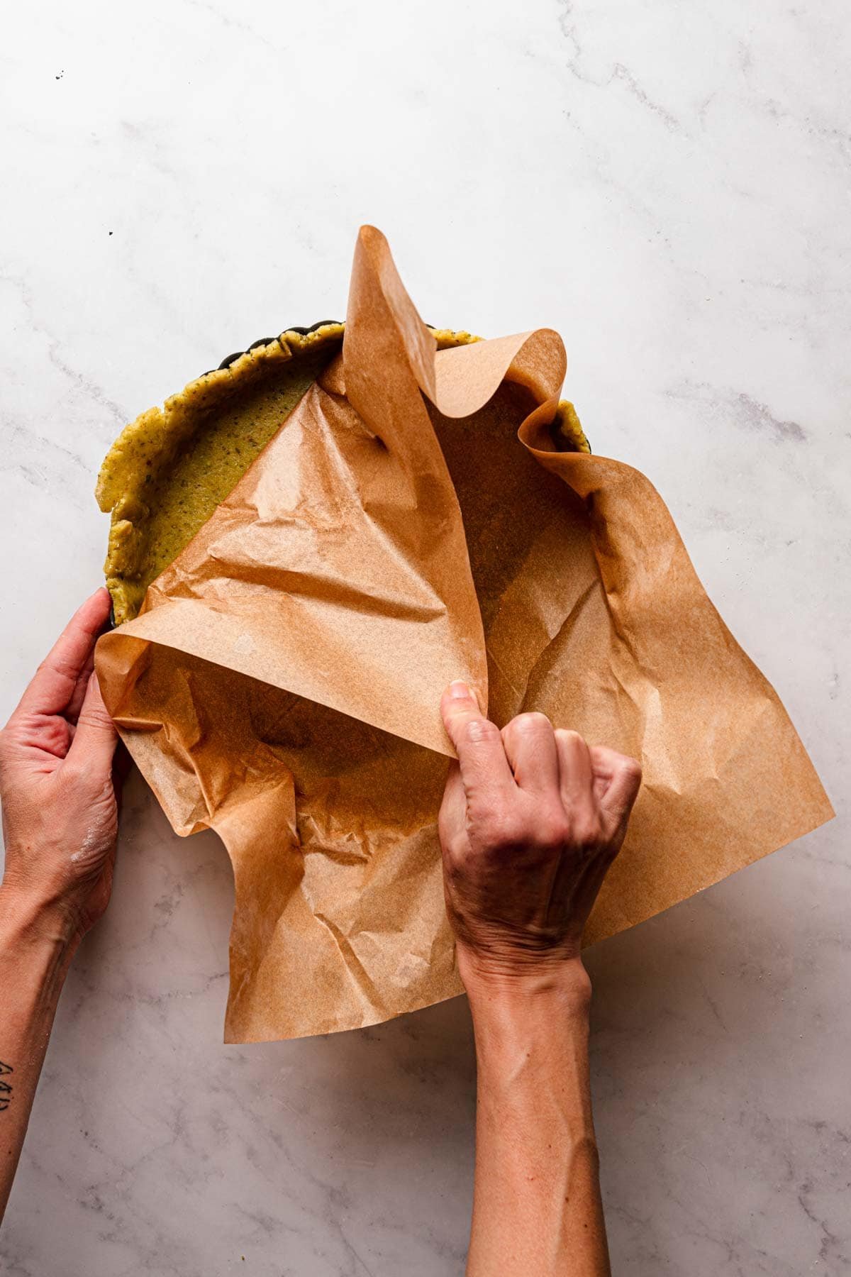 A hand removing parchment paper.