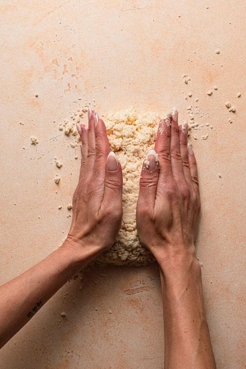 A food processor bowl with flour, butter and cream cheese chunks.
