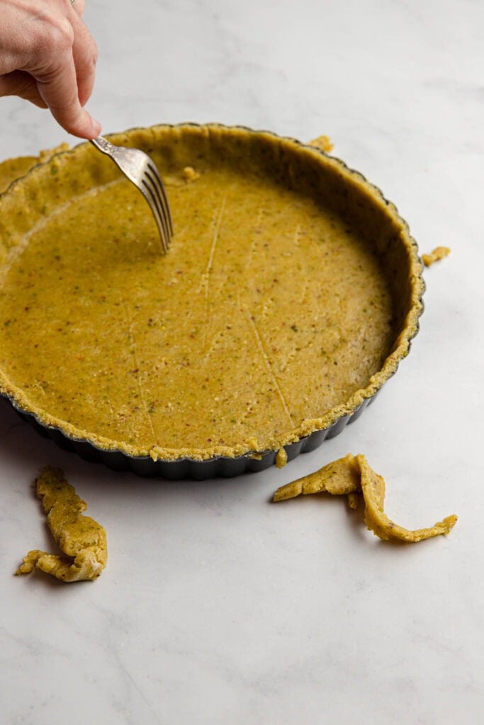 Pricking tart dough with a fork.