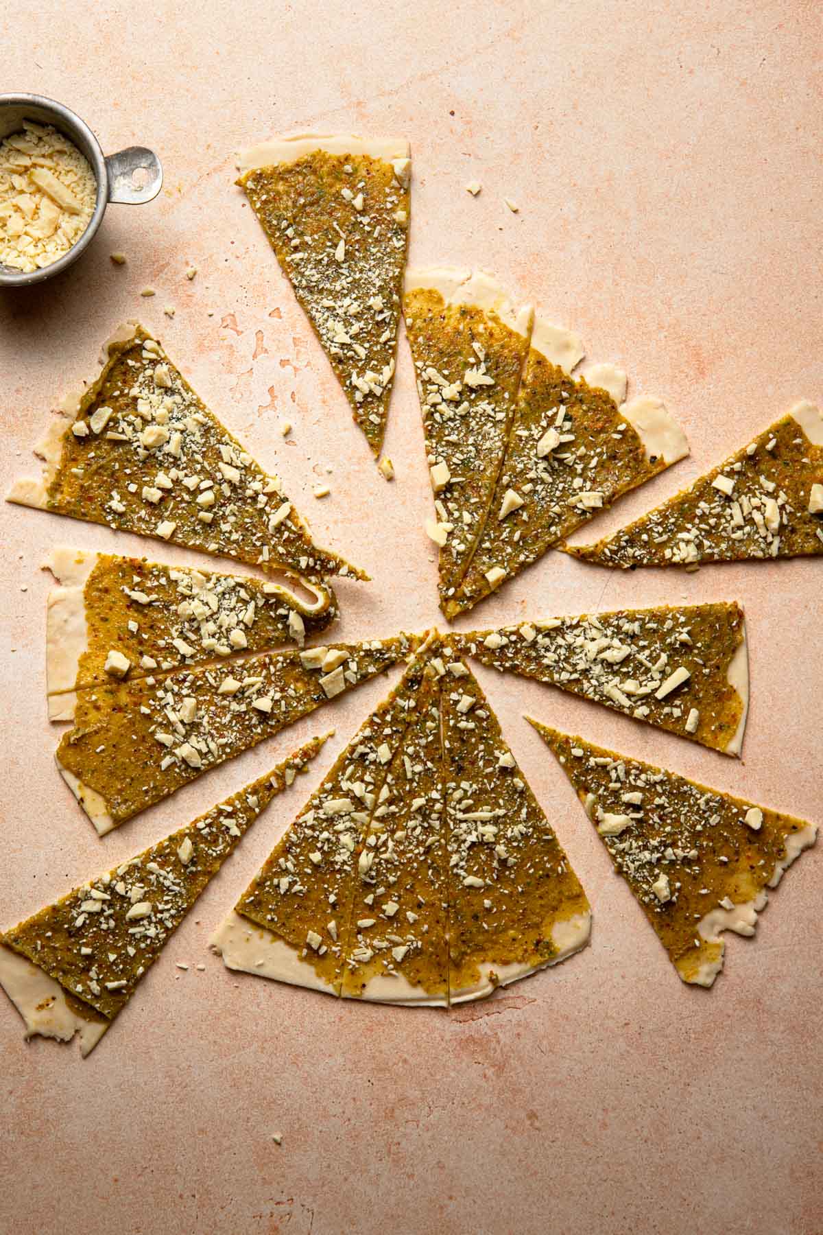 Triangle shaped cut dough topped with pistachio cream and chopped chocolate.