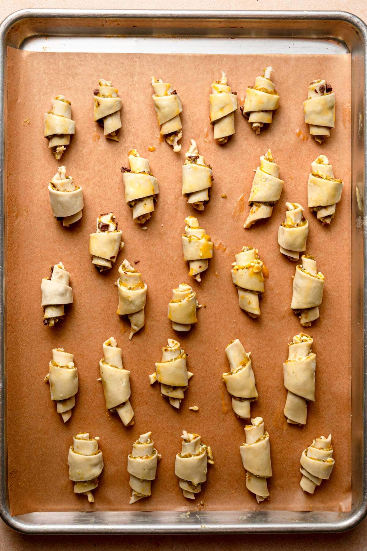 Raw rugealch cookies placed on a baking sheet lined with parchment paper.