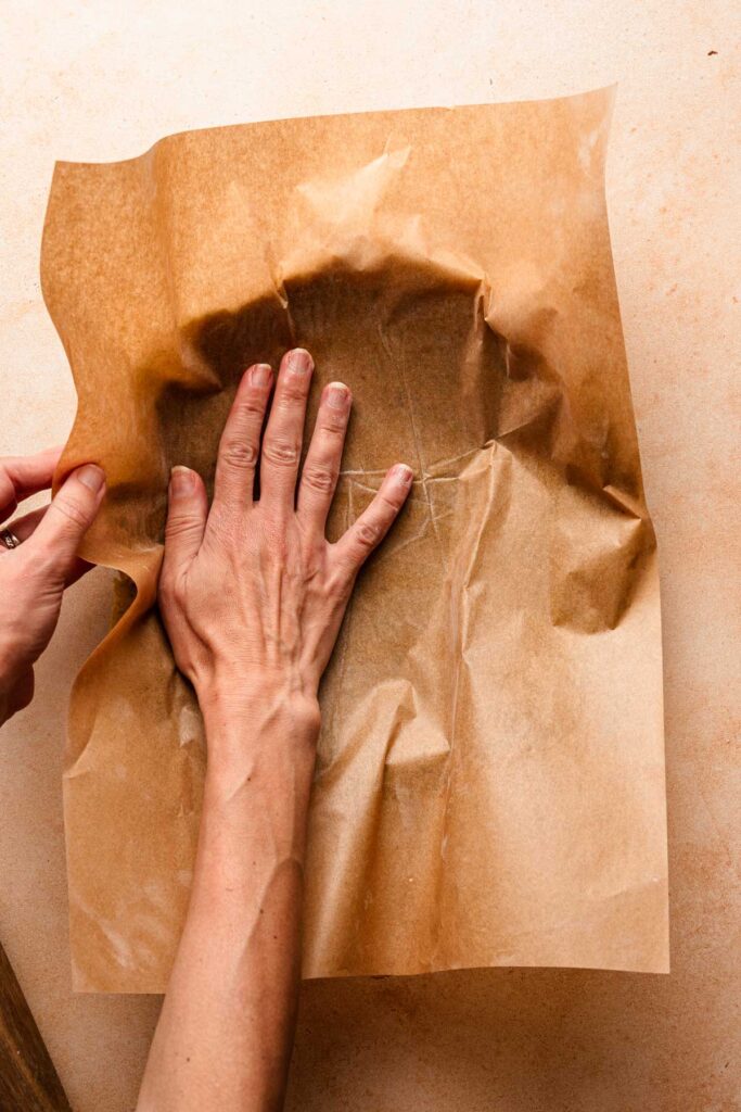 A hand pressing dough into the tart shell.