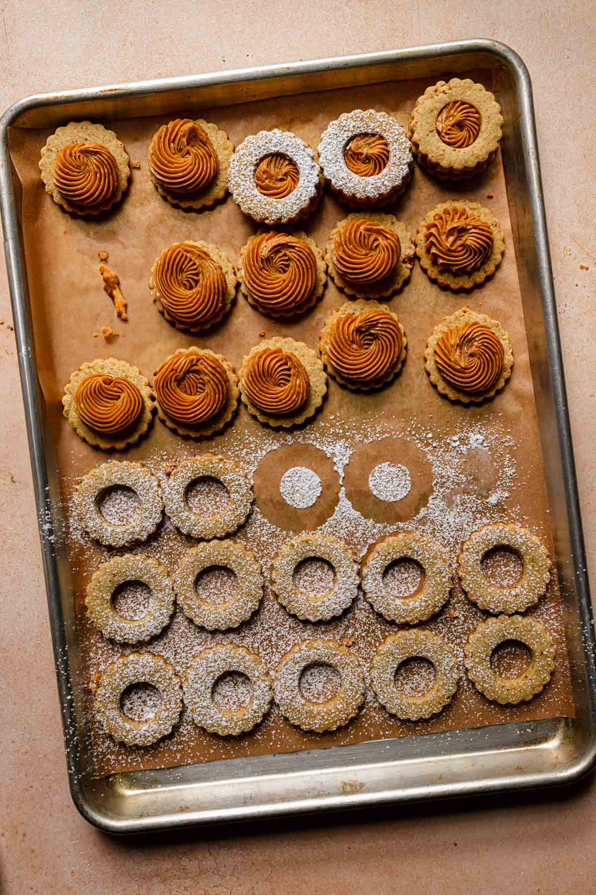 A pan with cookies topped with pistachio caramel cream.