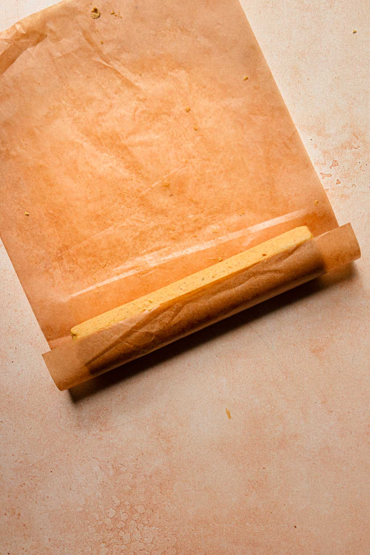 Rolled dough in a pieces of parchment paper.