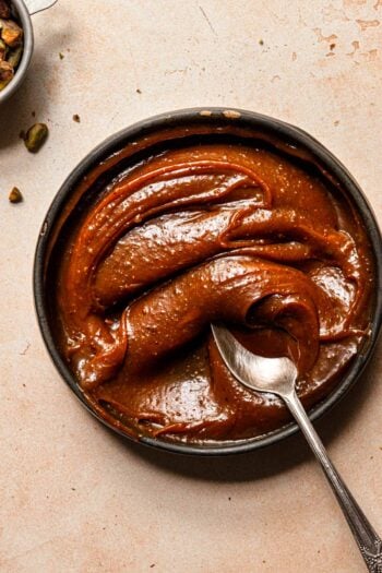 A bowl filled with caramel and a spoon.